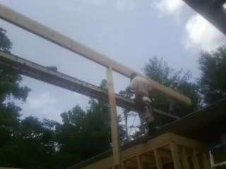 Carpenter setting a ridge beam over a new addition frame — Ice Dam Removal by Roofing Brothers in Glassboro