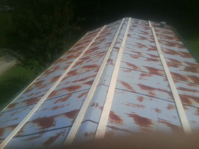 Rusted metal roof panels with new wood purlins before replacement — Storm Damage Roof Repair in Glassboro by Roofing Brothers