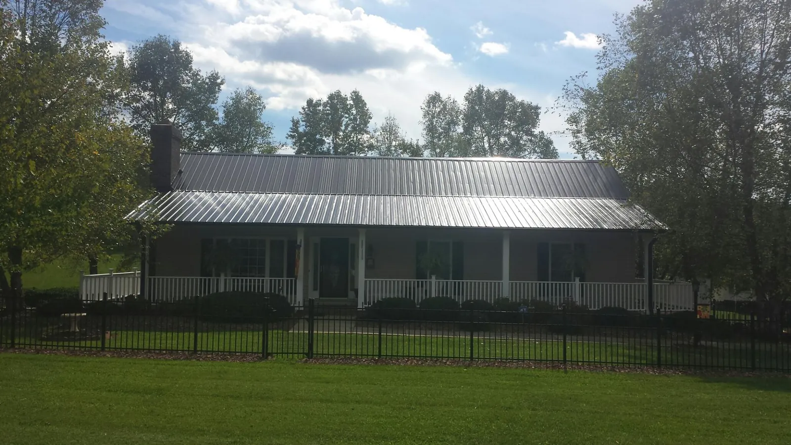 Gray metal roof on a brick ranch with a full width front porch — Gutter Guard Installation work by our crew in Glassboro